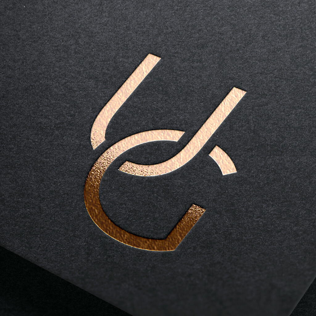 Abb.: Werner Design - Logodesign, Logoentwicklung; elegante UG Logo für online Galerie als Close Up in Goldfolie samt Prägung auf schwarzem Papier, Thumbnail Bild