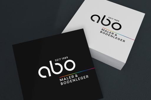 Dargestellt: Logo (Wort-/Bildmarke) „ABO, Maler und Bodenleger“, Farbvarianten gedruckt auf Karton.